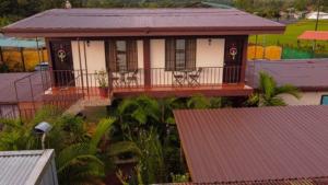 a house with chairs on the balcony of it at Cabinas Colibri in Fortuna