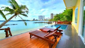 eine Terrasse mit Sitzbank und Blick aufs Wasser in der Unterkunft Try Palace Resort Sihanoukville in Sihanoukville