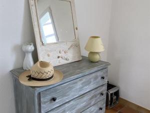 a mirror and a hat on top of a dresser at Maison calme avec jardin, proche plages et centre, 2 chambres, 4 couchages, ménage inclus - FR-1-246A-163 in Saint-Denis-dʼOléron