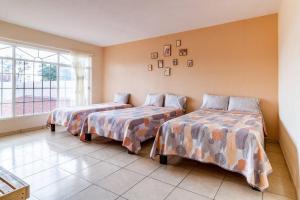 a bedroom with two beds and a large window at CASA DE CAMPO TERRAZA CHAPALA AJIJIC CAJITITLAN in Ixtlahuacán de los Membrillos
