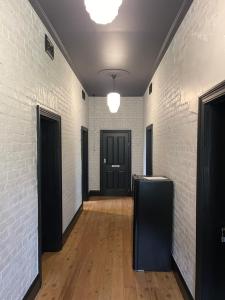 un pasillo con paredes de ladrillo blanco y una puerta negra en Riders’ Rest Nundle en Nundle