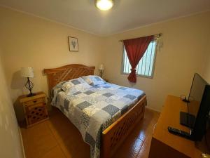 1 dormitorio con cama, mesa y ventana en Cabaña Bahía Loreto - Bahia Inglesa, en Caldera