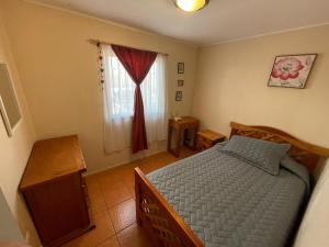 a bedroom with a bed and a window at Cabaña Bahía Loreto - Bahia Inglesa in Caldera