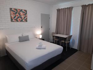 a hotel room with a bed and a table at Junction Motel Wagga in Wagga Wagga