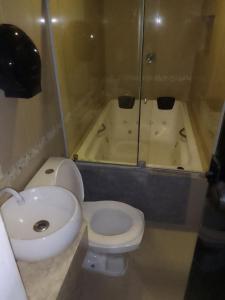 La salle de bains est pourvue de toilettes, d'un lavabo et d'une baignoire. dans l'établissement Hotel Entre Rios, à Paraíso do Tocantins