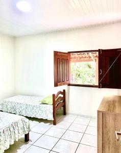 een kamer met 2 bedden en een raam bij Casa do Pôr do Sol in Triunfo