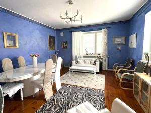 a dining room with blue walls and a table and chairs at 80m2 Central Lahti Apartment @Karjalankatu in Lahti