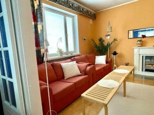 a living room with a red couch and a fireplace at 80m2 Central Lahti Apartment @Karjalankatu in Lahti