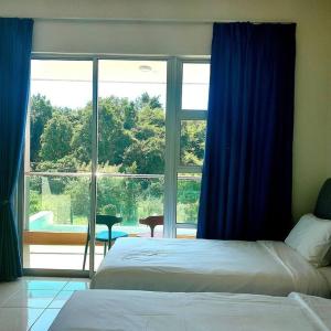 a bedroom with two beds and a large window at IMPIAN STAY #2 Semi Bungalow House in Kuah +31 photos