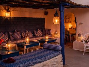 a living room with a couch and two tables with candles at Hotel-Restaurant Le Kaouki in Sidi Kaouki
