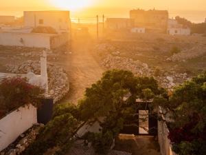 a sunrise over a road with trees and buildings at Hotel-Restaurant Le Kaouki in Sidi Kaouki