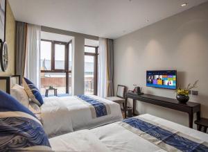1 Schlafzimmer mit 2 Betten und einem Flachbild-TV in der Unterkunft Tangfu Boutique Hotel in Peking