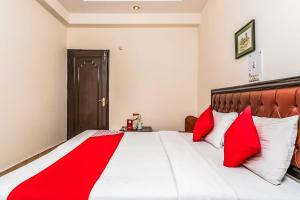 a bedroom with a large bed with red pillows at Super OYO Hotel City Castle in New Delhi