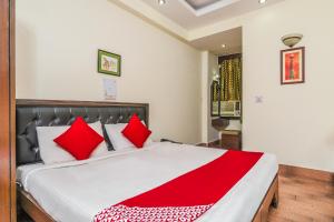 a bedroom with a large bed with red pillows at Super OYO Hotel City Castle in New Delhi