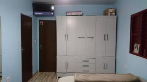 a bedroom with a large white cabinet and a bed at Residencial Silva in Bonito +1 photo