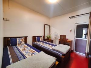 um quarto com 2 camas, uma mesa e um espelho em KPL Holiday Homes em Hatton