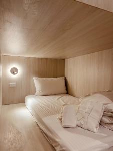 uma cama com lençóis brancos e almofadas num quarto em 婧仕女微旅 em Hou-lung-tzu