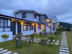 a house with chairs and a table in the yard at Bi La Homestay in Luye