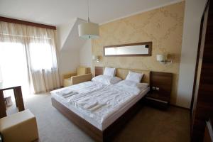 Airport Wellness Panzio في هایدوسوبوسلو: غرفة نوم بسرير كبير في غرفة