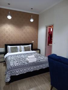 1 dormitorio con 1 cama y 1 silla azul en Hotel Zaira, en Tiflis