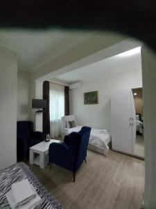 Habitación de hotel con cama, sofá y sillas en Hotel Zaira, en Tiflis
