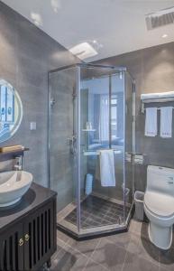 La salle de bains est pourvue d'une douche, de toilettes et d'un lavabo. dans l'établissement Tangfu Boutique Hotel, à Pékin