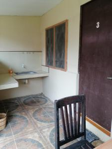 ein leeres Zimmer mit einem Stuhl, einer Theke und einer Tür in der Unterkunft Walkerz Inn in Panglao