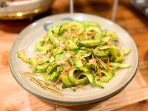 a plate of food with broccoli and carrots on a table at Hotel Abest Naha Kokusai Street in Naha