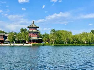 a large building on the edge of a lake at Guxiang Bushe - Nanluoguxiang Branch in Beijing