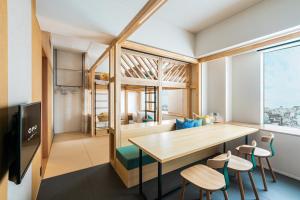 een kamer met een tafel en stoelen en een groot raam bij OMO5 Kumamoto by Hoshino Resorts in Kumamoto