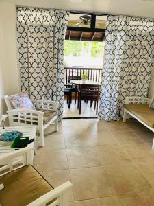 uma sala de estar com mobiliário branco e uma mesa em Lovely Beachfront 2 bedrooms condo with 2 pools em Las Terrenas