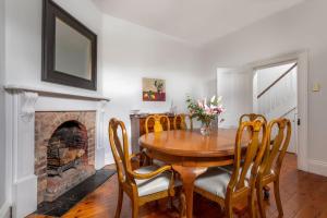 uma sala de jantar com uma mesa e cadeiras e uma lareira em Two Worlds Townhouse em Launceston