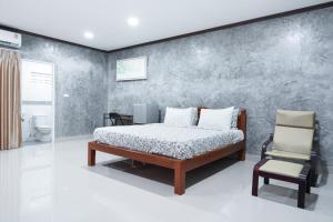 1 dormitorio con 1 cama y 1 silla en Guesthouse Phuket Airport, en Ban Bo Han