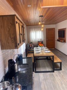 a kitchen with a table and a living room at Hospedagem Casa Lorenzi 2 in Urubici