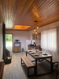 a kitchen with a wooden ceiling with a table and chairs at Hospedagem Casa Lorenzi 2 in Urubici