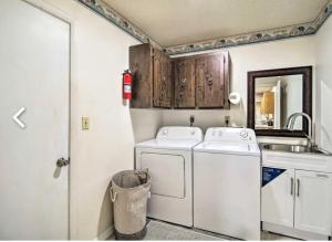 a small laundry room with two washes and a sink at Vacation Home 4 Bedrooms 3Baths 10 beds home in Melbourne