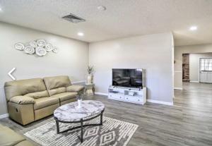 a living room with a couch and a tv at Vacation Home 4 Bedrooms 3Baths 10 beds home in Melbourne