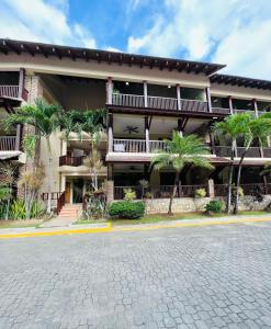 un bâtiment avec des palmiers en face d'une rue dans l'établissement Lovely Beachfront 2 bedrooms condo with 2 pools, à Las Terrenas