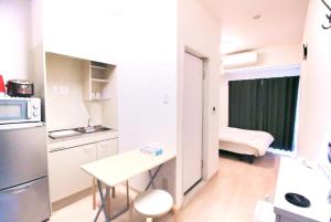 une petite cuisine avec une table et un réfrigérateur dans l'établissement Uhome Kanda Hotel, à Tokyo 93 autres photos