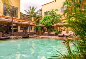 a pool with chairs and umbrellas next to a building at Superior Room Space Available in Accra