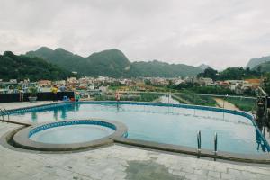 a large swimming pool with mountains in the background at Muong Thanh Luxury Son La in Sơn La