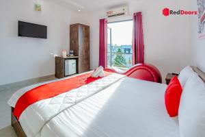 a bedroom with a large white bed with red accents at The Sun Hotel in Ho Chi Minh City