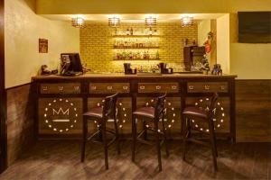 a bar with three stools in front of a counter at Three Crowns Hotel in Lviv