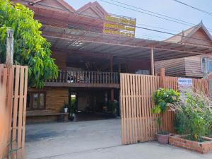 un bâtiment avec une clôture en bois devant lui dans l'établissement Sunshine Hotel Kampot, à Kampot