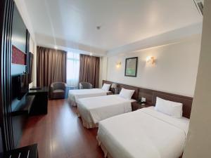 a hotel room with two beds and a television at Muong Thanh Thanh Nien Vinh in Vinh