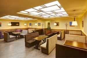 Three Crowns Hotel في إلفيف: غرفة انتظار مع طاولات وأرائك