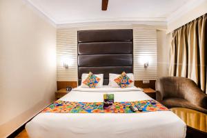 a hotel room with a bed and a chair at FabHotel BMK Grand in New Delhi +23 photos