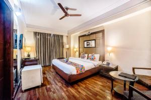a hotel room with a bed and a ceiling fan at FabHotel BMK Grand in New Delhi