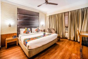um quarto de hotel com uma cama e uma televisão em FabHotel BMK Grand em Nova Deli