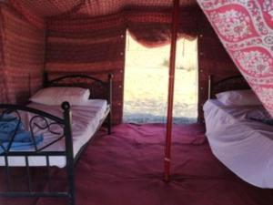 a small room with two beds and a window at Panorama Camp Bidiya in Al Wāşil